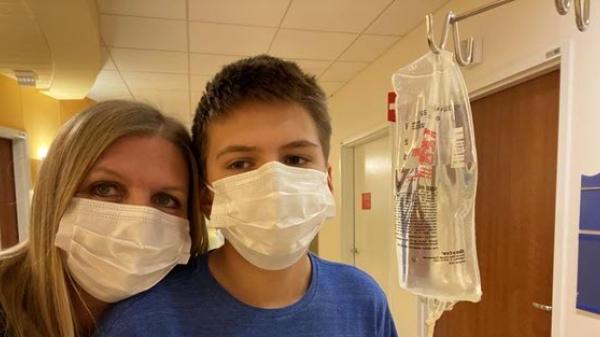 一位员工和她的儿子戴着从医院取来的静脉输液袋